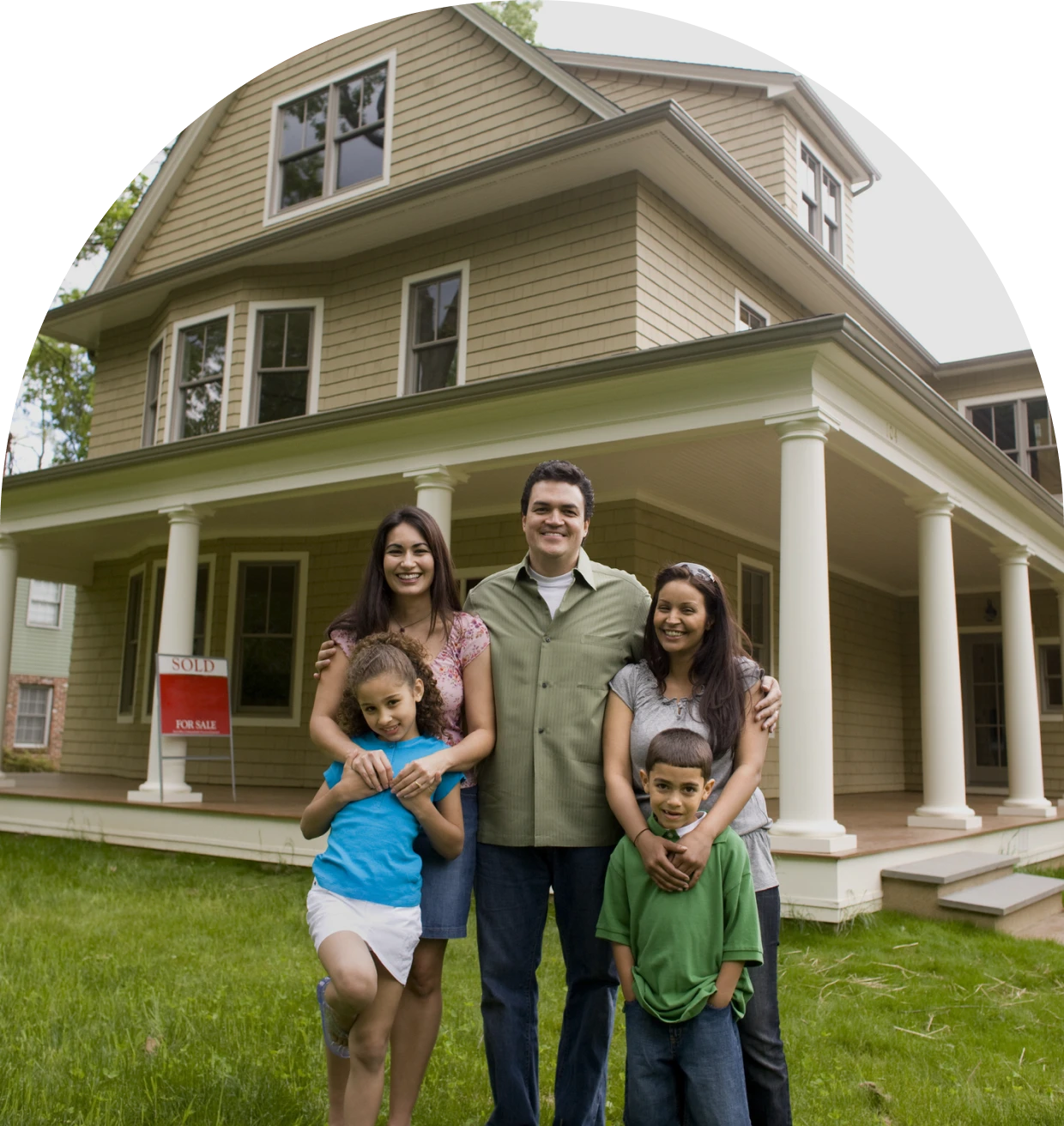 Family smiling in front of their house